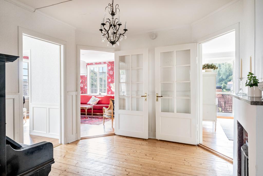 Allrum med bröstpanel med speglar, vackra glasdörrar och bevarade trägolv. 