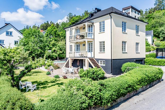 Vacker 20-talsvilla med putsad fasad och spröjsade fönster.