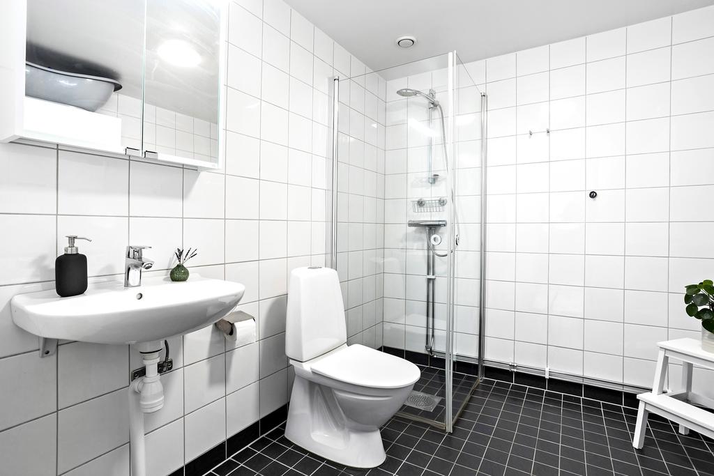 Stort badrum med kombinerad tvättstuga inkl. tvättmaskin och torktumlare, duschhörna, kläd- och spegelskåp