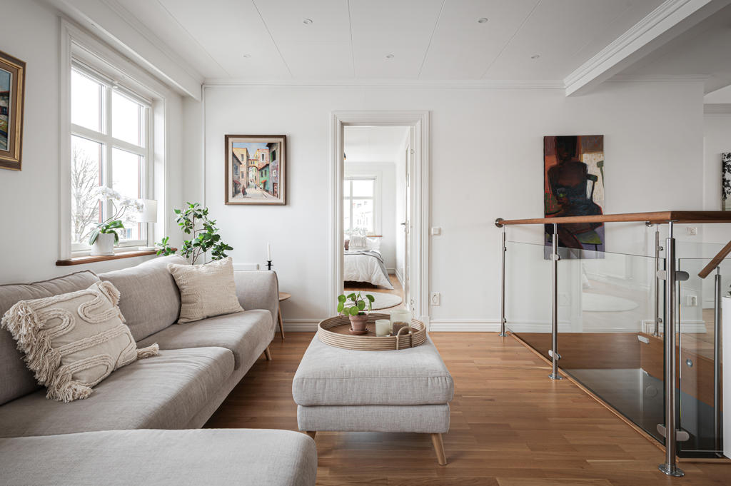 Allrum med glasat räcke ner mot entrén