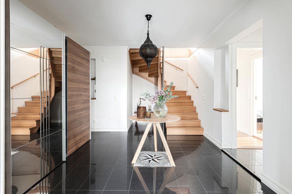 Rymlig entréhall med kompassros i golvet