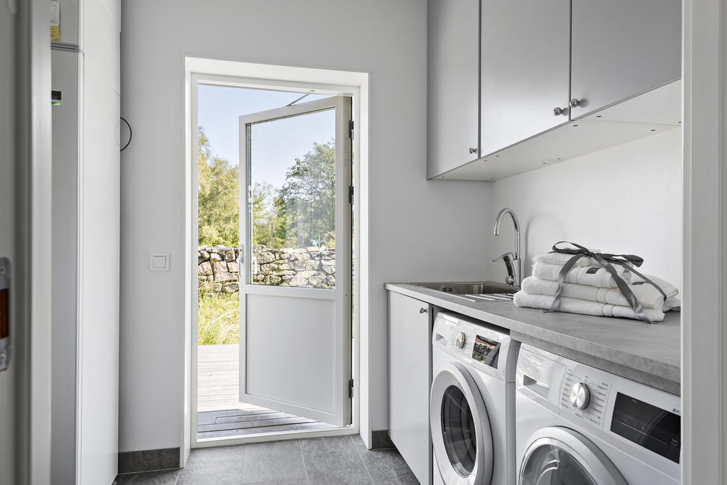 Rymlig tvättstuga med tvättmaskin och torktumlare. Arbetsbänk och överskåp för förvaring. 
Utgång från tvättstugan till baksidan av huset med altandäck som uteplats. 