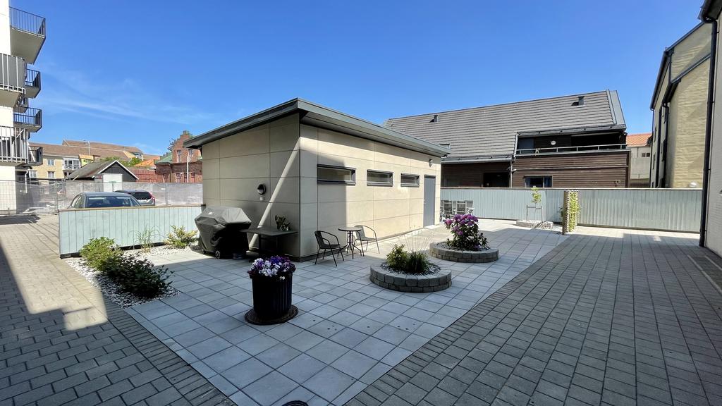 Välskött innergård med grillplats och utemöbler