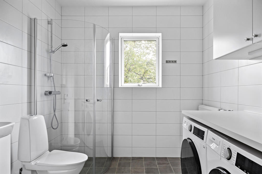 Badrum med tvättmaskin och torktumlare