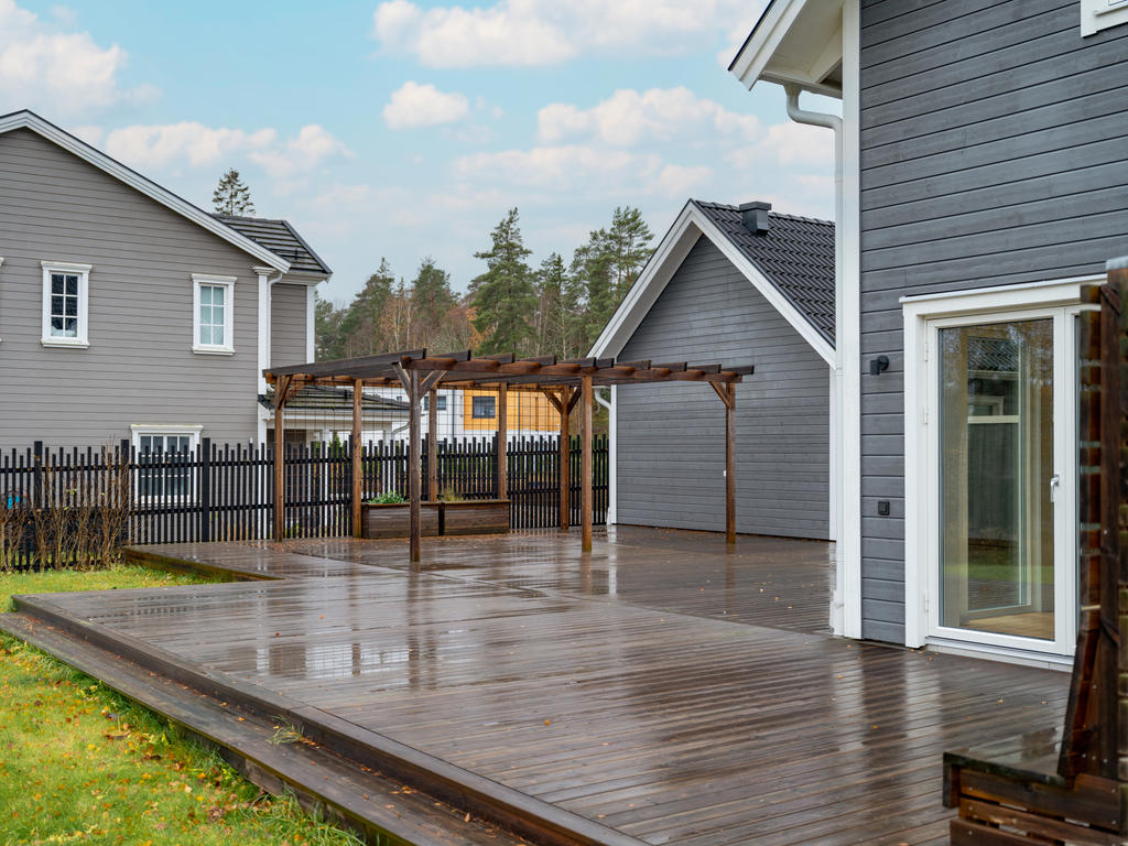 Trädäckad altan med platsbyggd pergola
