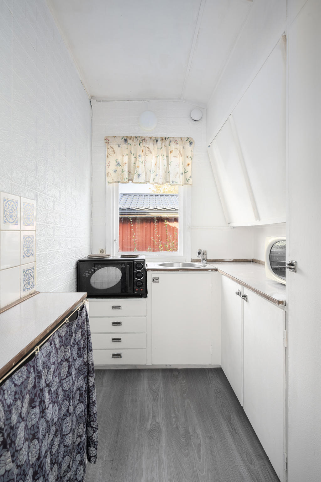 Originalkök med tidstypiska snedställda köksskåp. Härligt ljusinsläpp från fönstren. Väggarna målades vita och nytt laminatgolv 2025