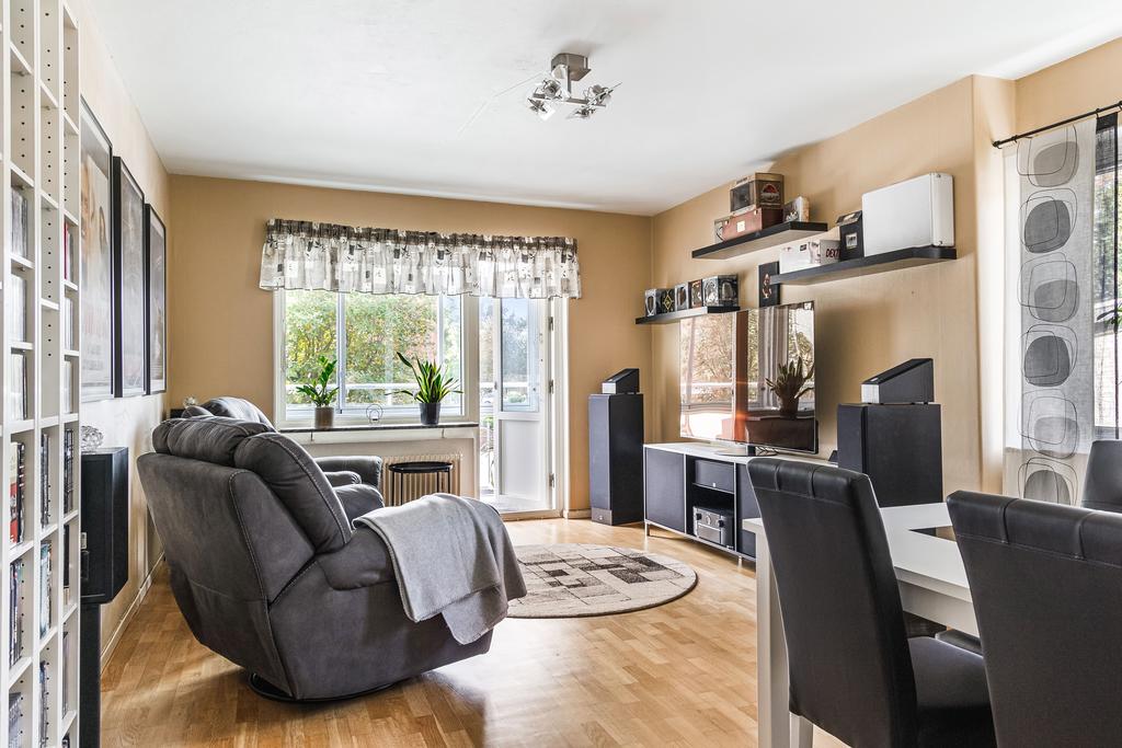 Bostadens vardagsrum upplevs ljust och luftigt där gavelläget ger ett extra ljusinsläpp med fönster på rummets ena långsida.