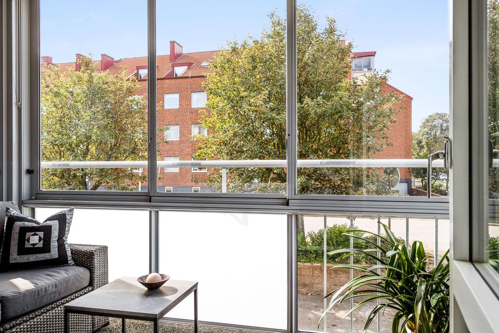Inglasad balkong som nås från bostadens vardagsrum. 