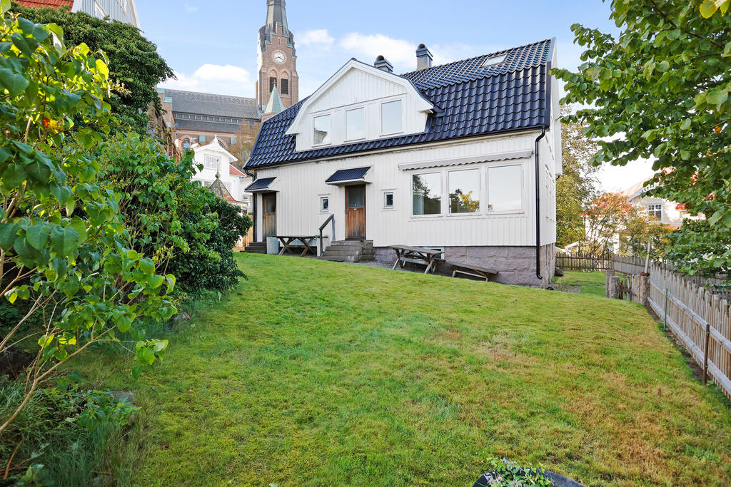Trädgårds vy mot de två entréerna till lägenheterna. Den vänstra går upp till andra våningsplanet och den högra är ingång till lägenheten på entréplan
