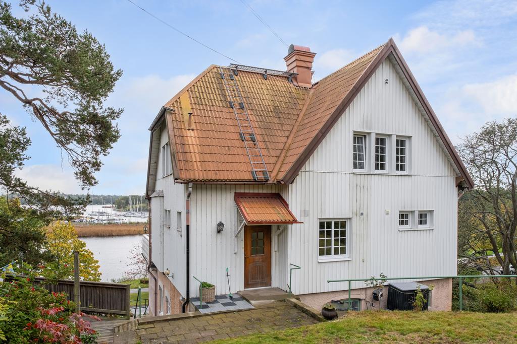 Trädgård och entré till entréplanet och vindsvåningen. Uteplatsen skymtar till vänster i bild.