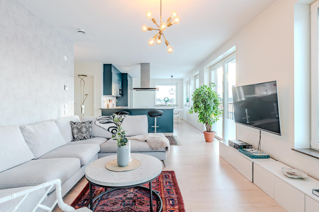 Ljust vardagsrum med öppen planlösning mot köket.