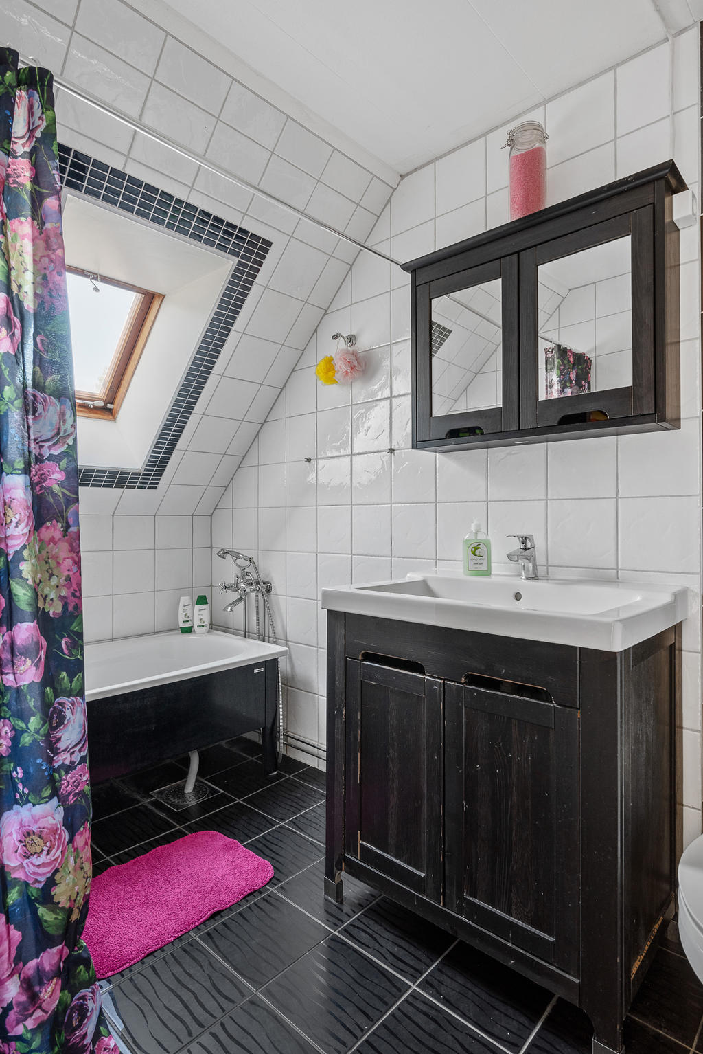Helkaklat badrum på det övre planet med golvvärme, badkar och wc samt tvättställ och kommod 