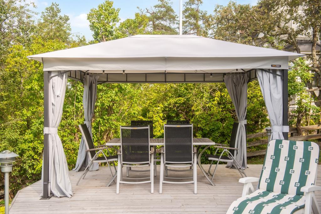 Trädäckets pergola intill grönskande natur