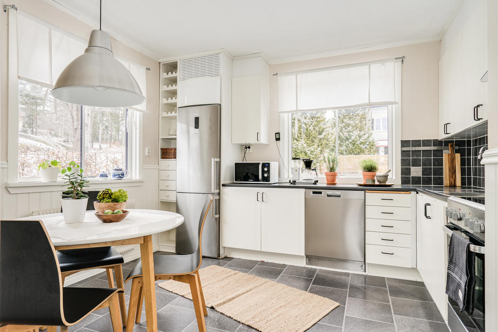 Renoverat kök med stilren inredning med plats för separat matplats.