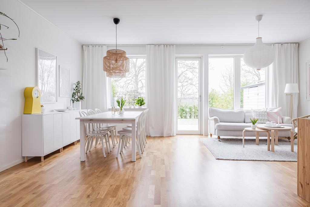 Stort ljust vardagsrum med plast för både soffgrupp och matbord