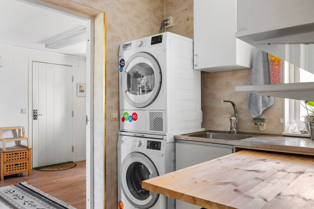 Tvättstuga intill kontor/gästrum och dörr till garaget
