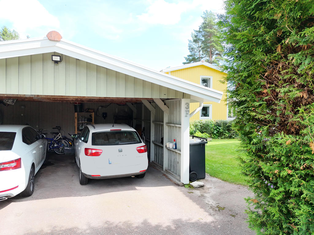 Parkering i carport framför huset. På området finns även flertalet gästparkeringar.