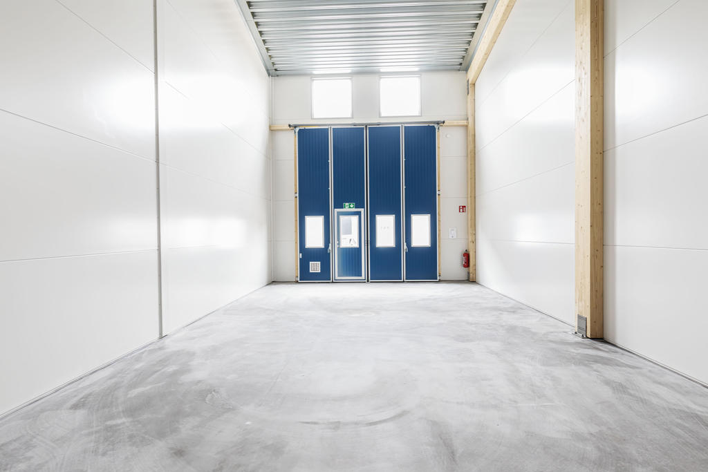 Exempelbild inifrån hög lokal, front vikport 4x4,5 meter samt fönster ovanför för ökat ljusinsläpp.