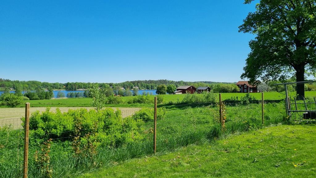 Vy från trädgården över de öppna landskapen och sjön nedanför