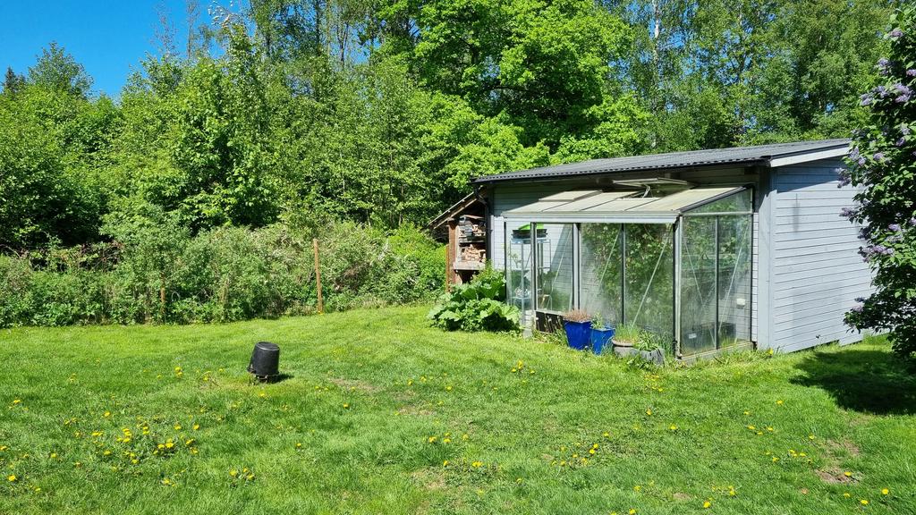 Litet växthus vidbyggt på förrådshus/gästhus