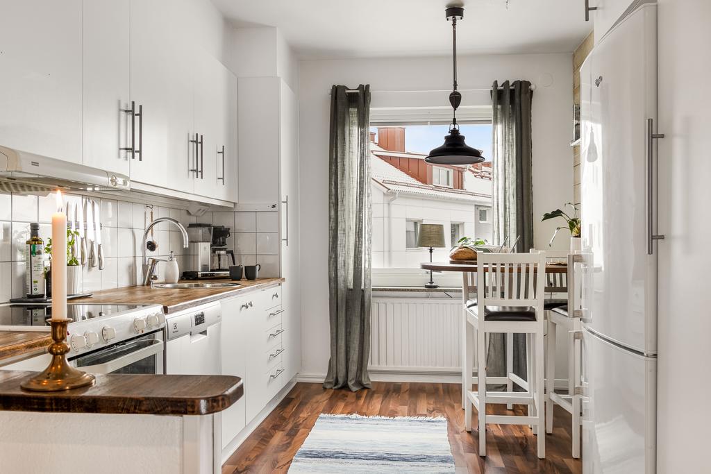 Bostadens kök är hemtrevligt och trivsamt. Den klassiskt vita köksinredningen i kombination med bänkskivor i ek samt vitmålad träpanel på vägg blir en mycket smakfull kombination.
