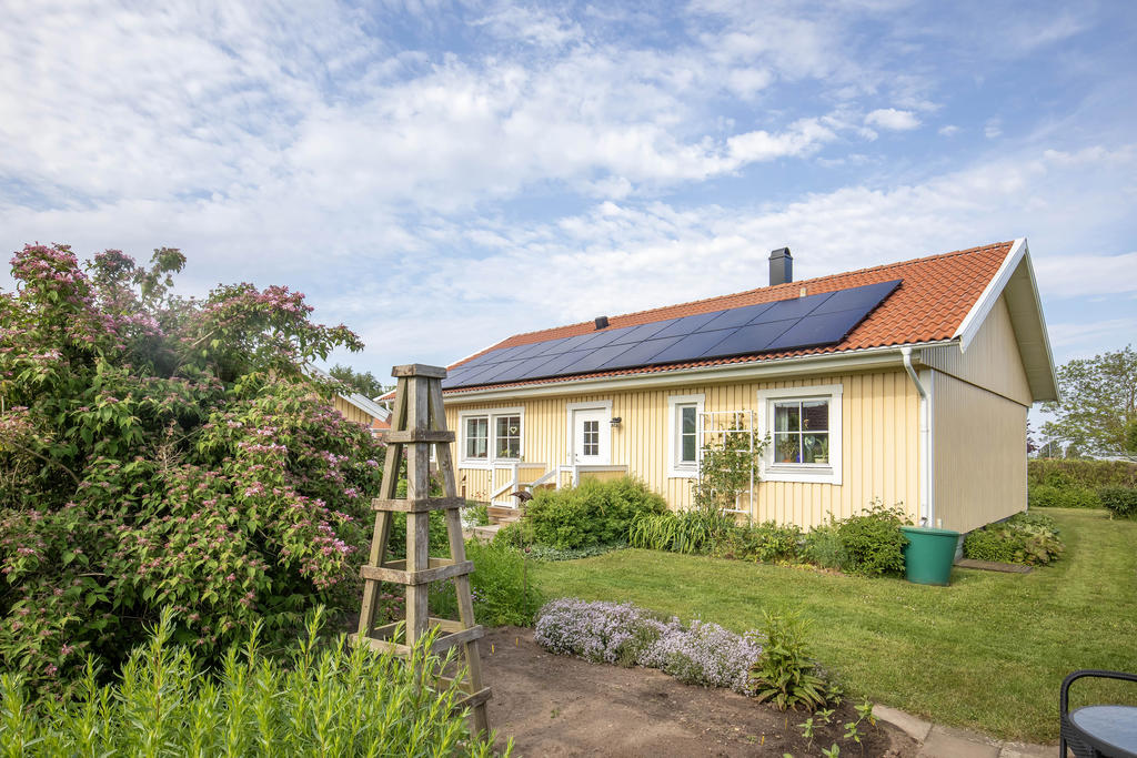 Prunkande trädgård sommartid. Solceller som producerar ca 8500kWh/år.