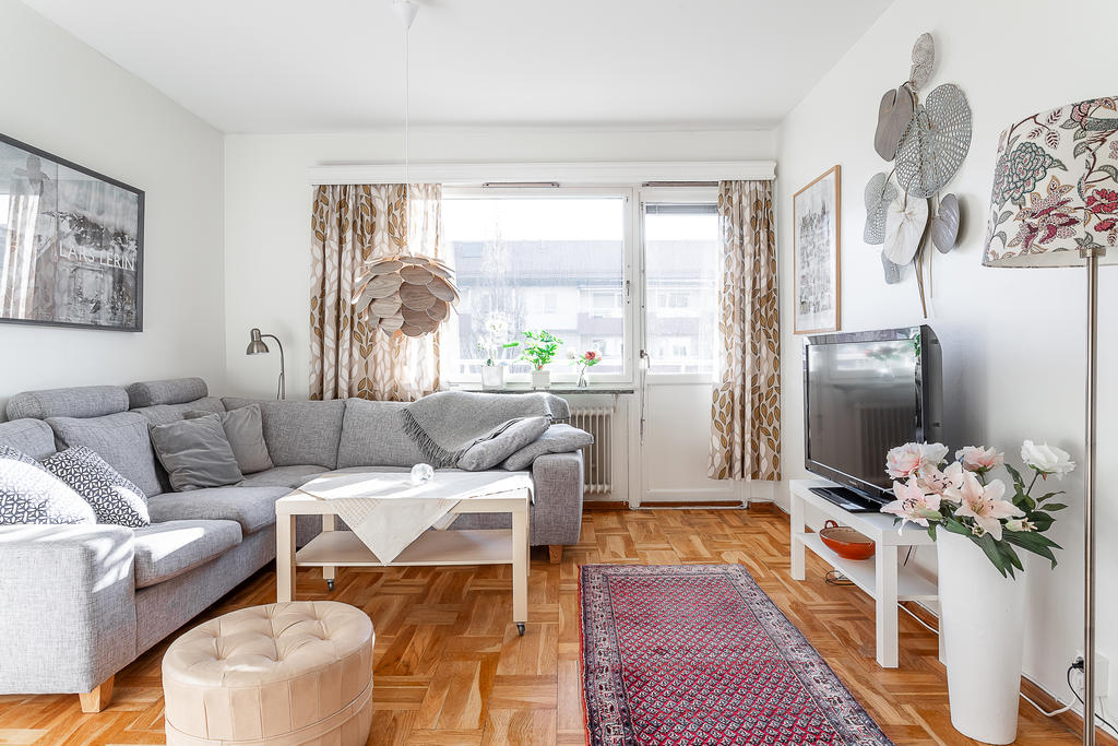 Ljust vardagsrum med utgång till bostadens balkong.