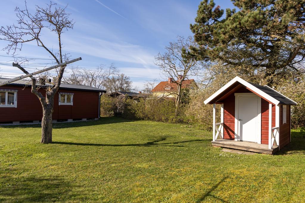 Lekstuga och gäststuga i bakgrunden
