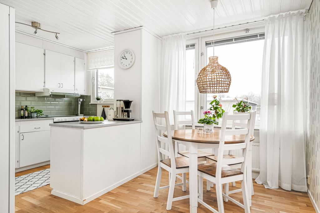 Kök i lugna färger med plats för matbord och vy över det lugna området 