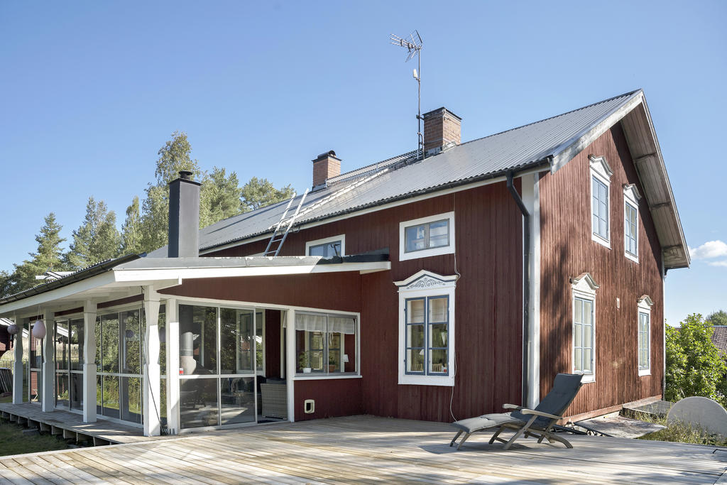 Husets baksida med inglasad altan och soldäck