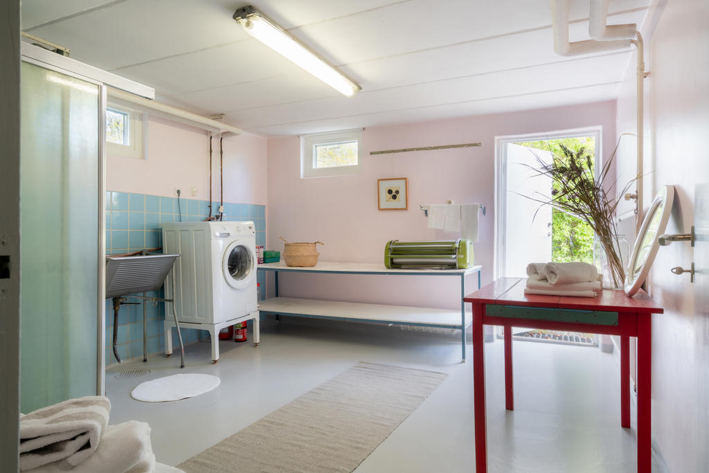 Tvättstuga och duschutrymme med utgång till gavelsida