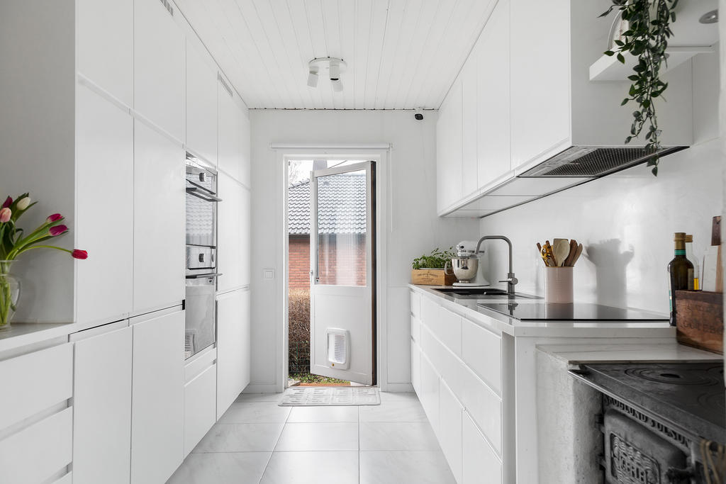 Modernt kök med gott om förvaring samt dubbla kylar och frysar. Här kan man gå ut till trädgården och ta sitt morgonkaffe