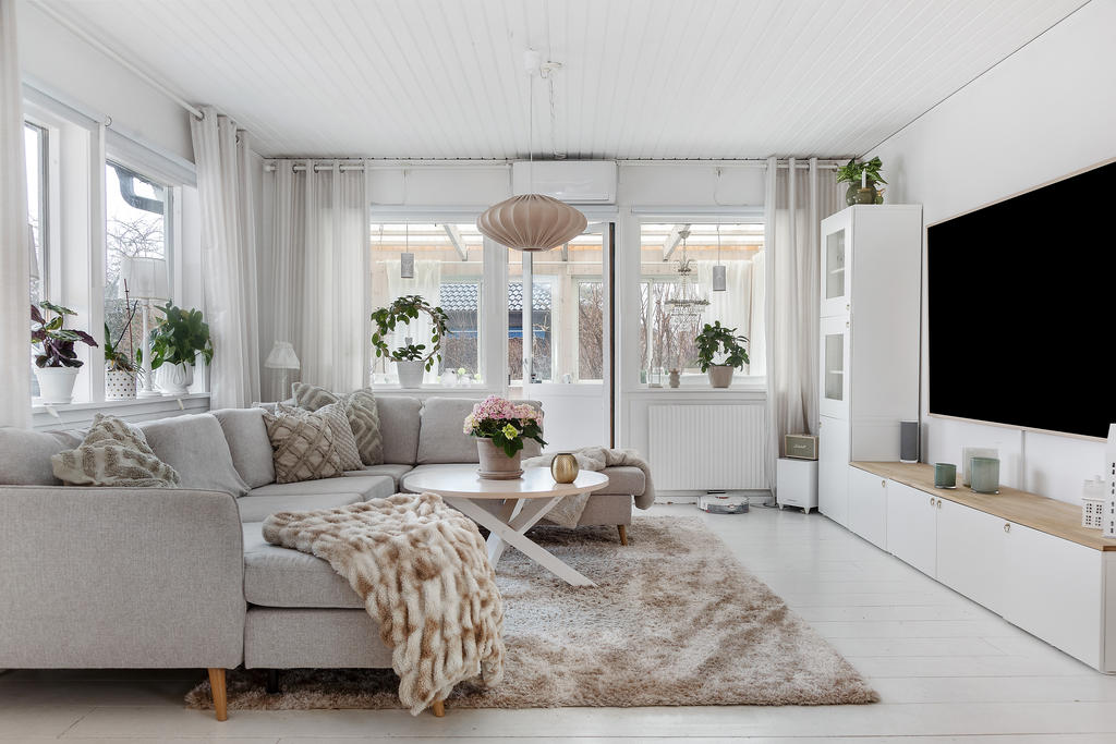 Stor vardagsrumsdel med plats för många nära och kära. Här finner vi utgången till det inglasade uterummet och altanen som sträcker sig längs husets framsida