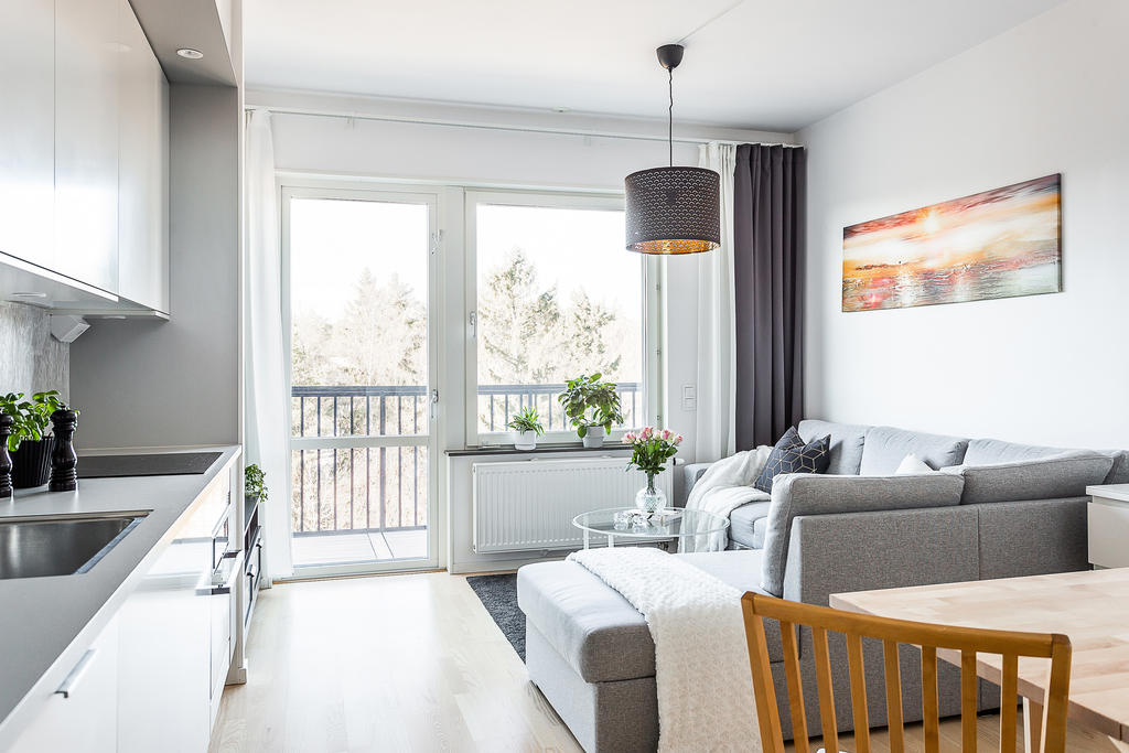 Vardagsrumsdel med ljusinsläpp samt utgång till bostadens balkong.