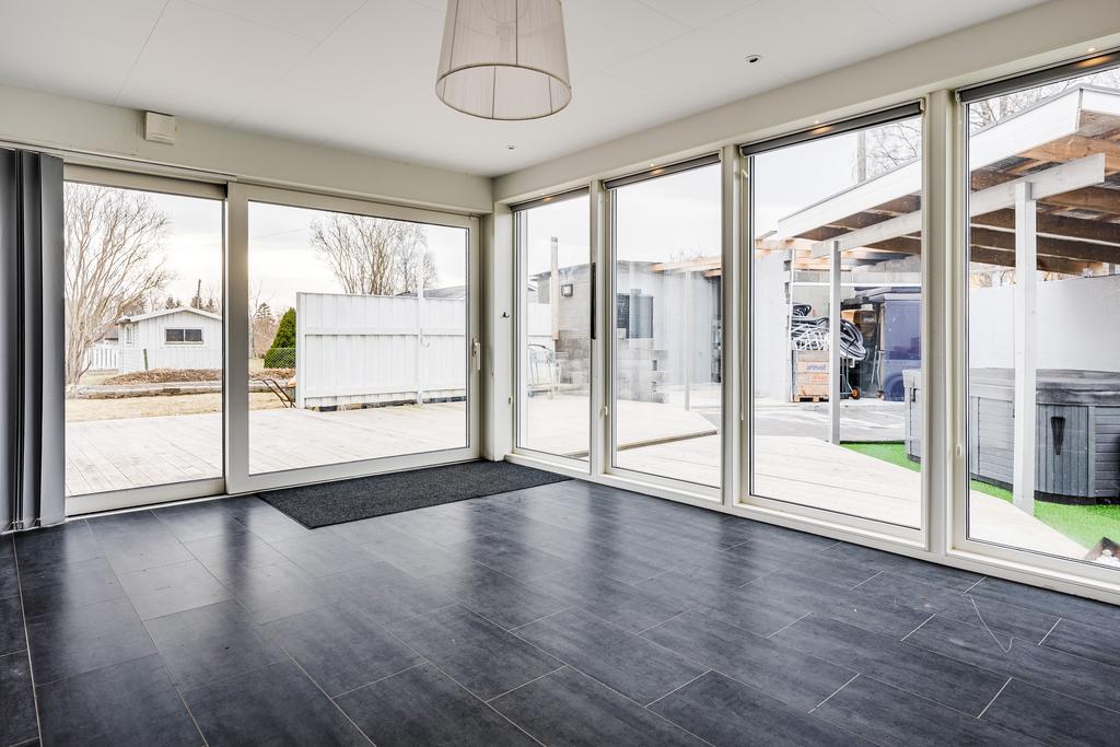 Stort härligt rum med stora fönsterpartier och skjutdörrar som gör att ute och inne möts på ett trevligt sätt.