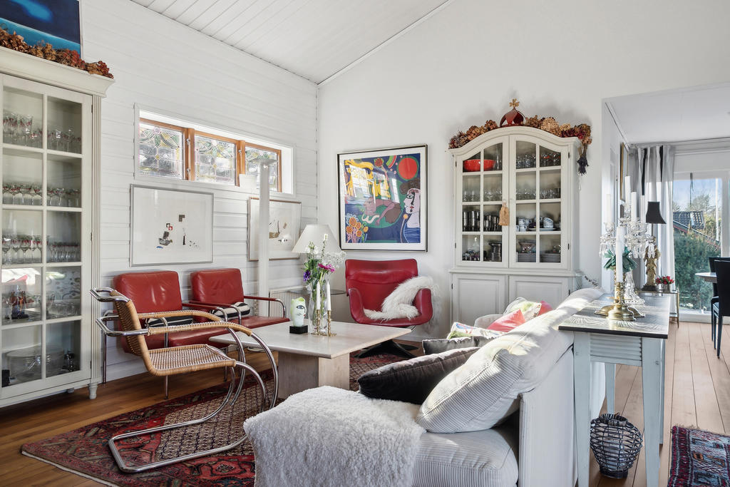 Varmt välkomnande och mysigt vardagsrum med en elegant, storslagen öppen spis som skapar en atmosfär av lugn och avkoppling. Perfekt för sköna kvällar med nära och kära.