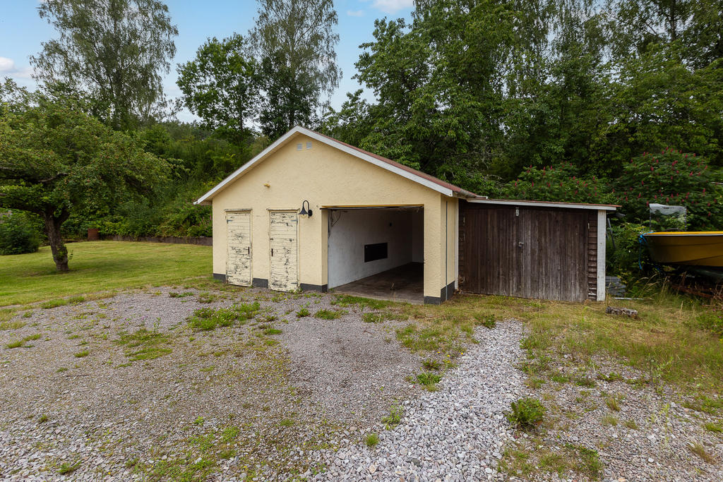 På baksidan finns en garagebyggnad med tillhörande förråd