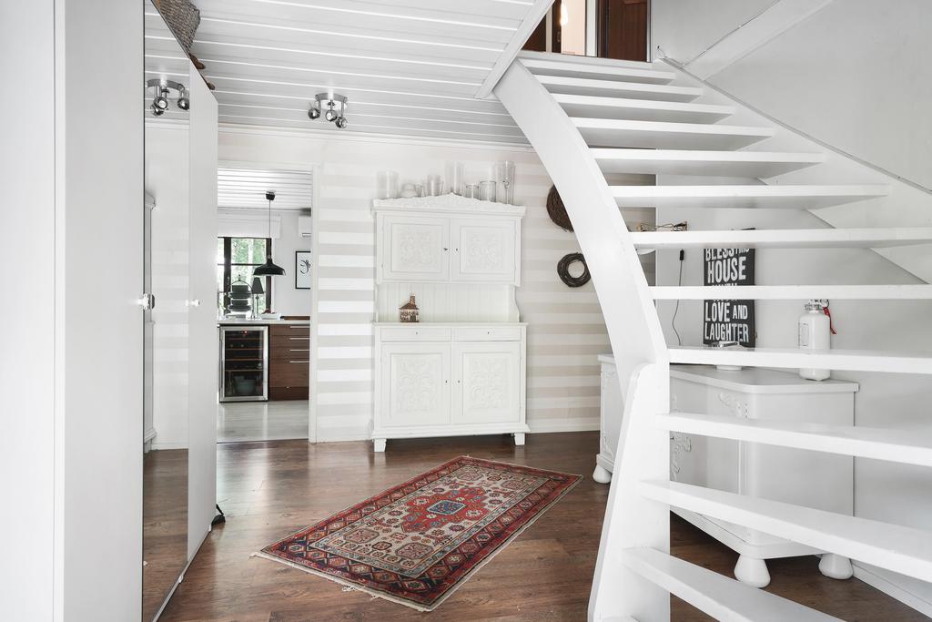 Rymlig hall med plats för fövaring och trapp upp till övre plan.