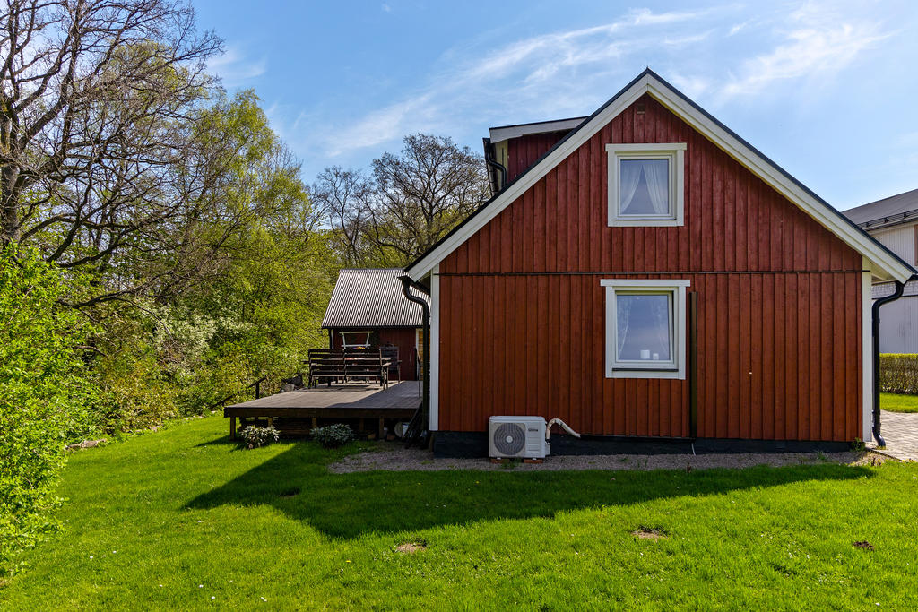 Tralldäck på baksidan med ingång till kök och vardagsrum