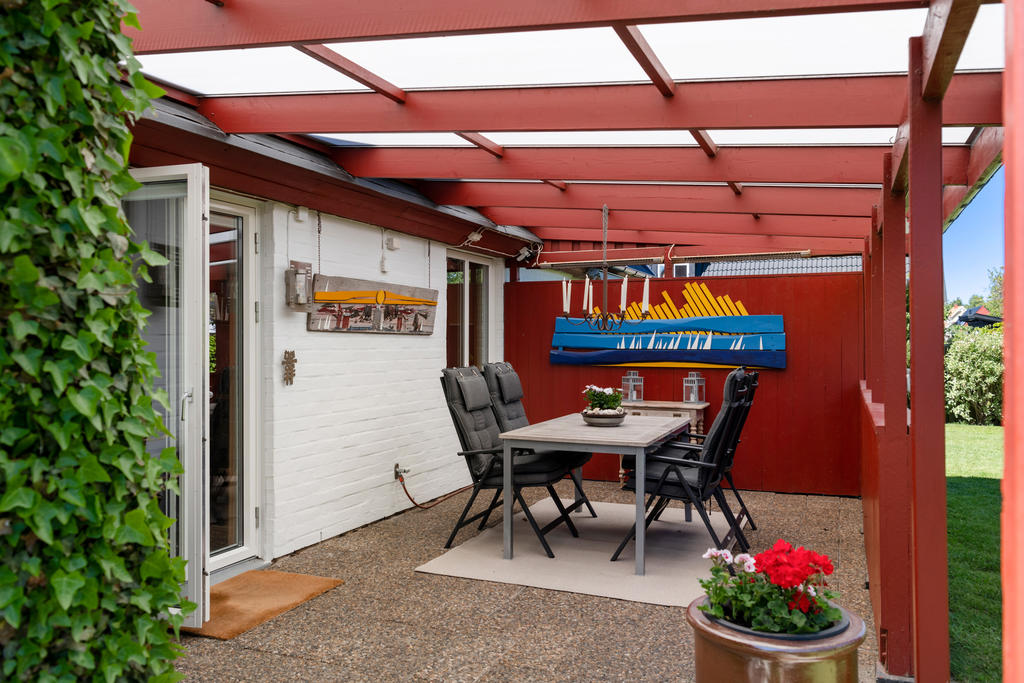 Mysig uteplats under tak för skugga eller skygg när sommarregnet hälsar på