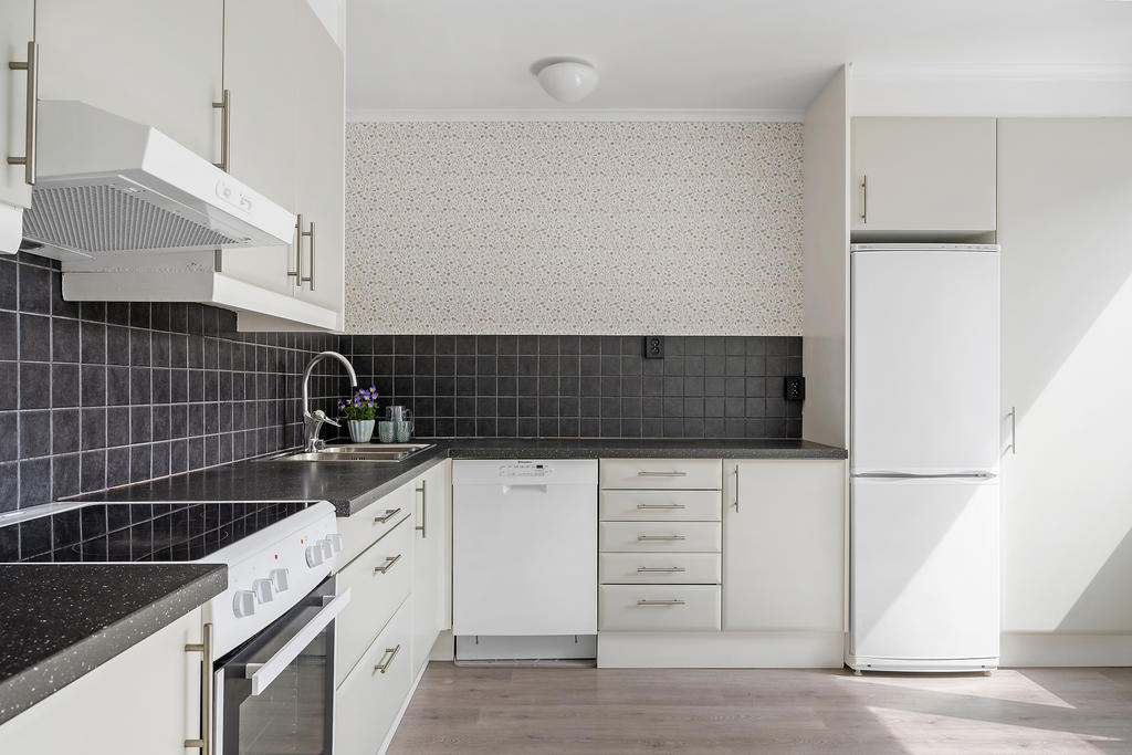 Kök i huset med gott om plats för matgrupp och utgång till uteplats på baksidan.