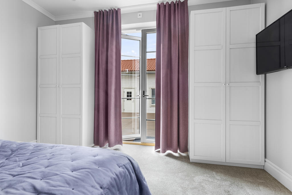 Master-bedroom med heltäckningsmatta,  hög pardörr i helglas ut till soldäcket