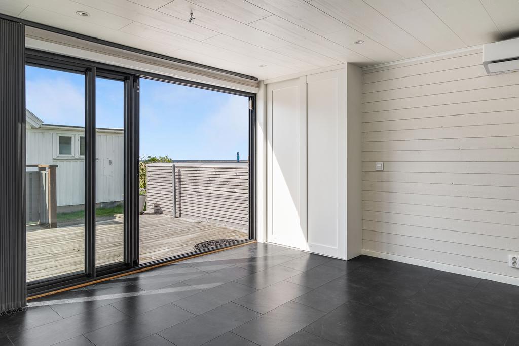 Det tidigare uterummet har byggts in till boyta och denna nya entrén är av isolerade skjutpartier i glas