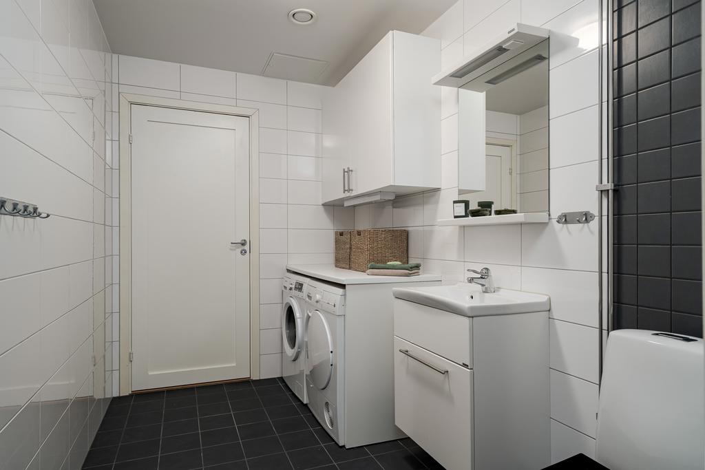 Stort helkaklat tvättrum med WC