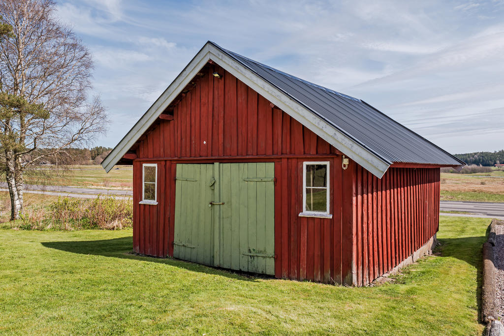 Garagebyggnad med träfasad och plåttak