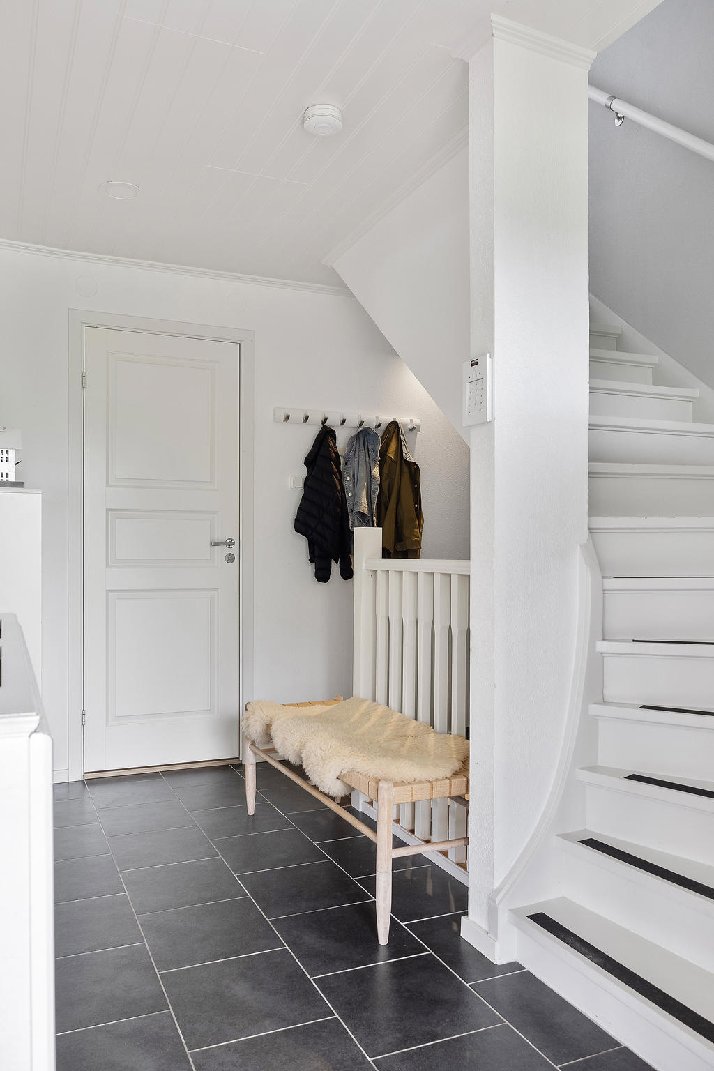 Hall med trappor till ovanvåning och källare