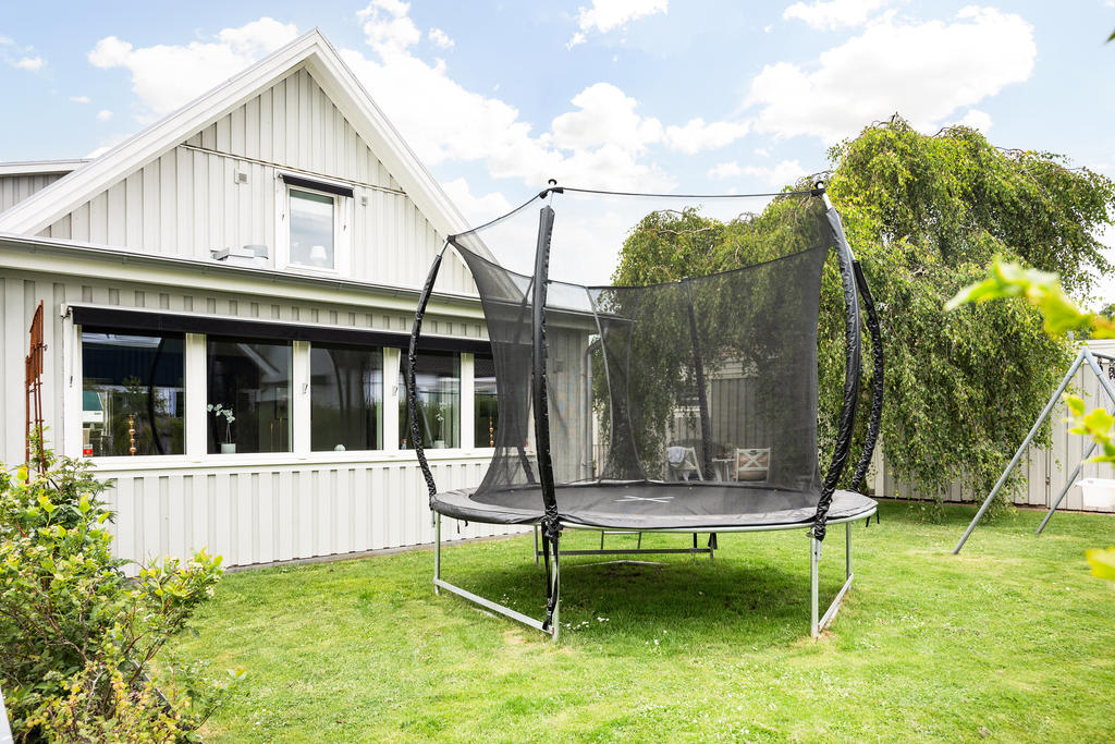 Trivsam baksida med plats för studsmatta för hoppglada barn!