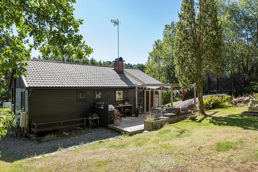 Fantastisk baksida av huset med praktiskt utekök och bra ytor som erbjuder plats för härliga middagar med vänner och familj.