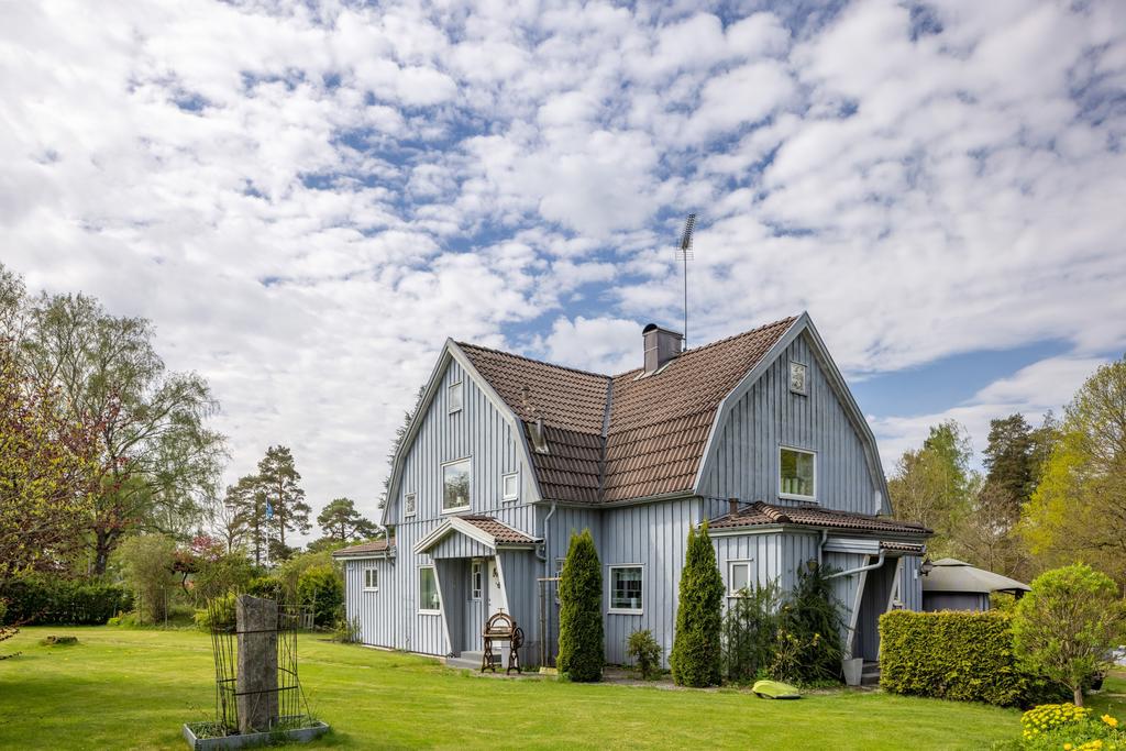 Entrén på framsidan med uppvuxen trädgård.
