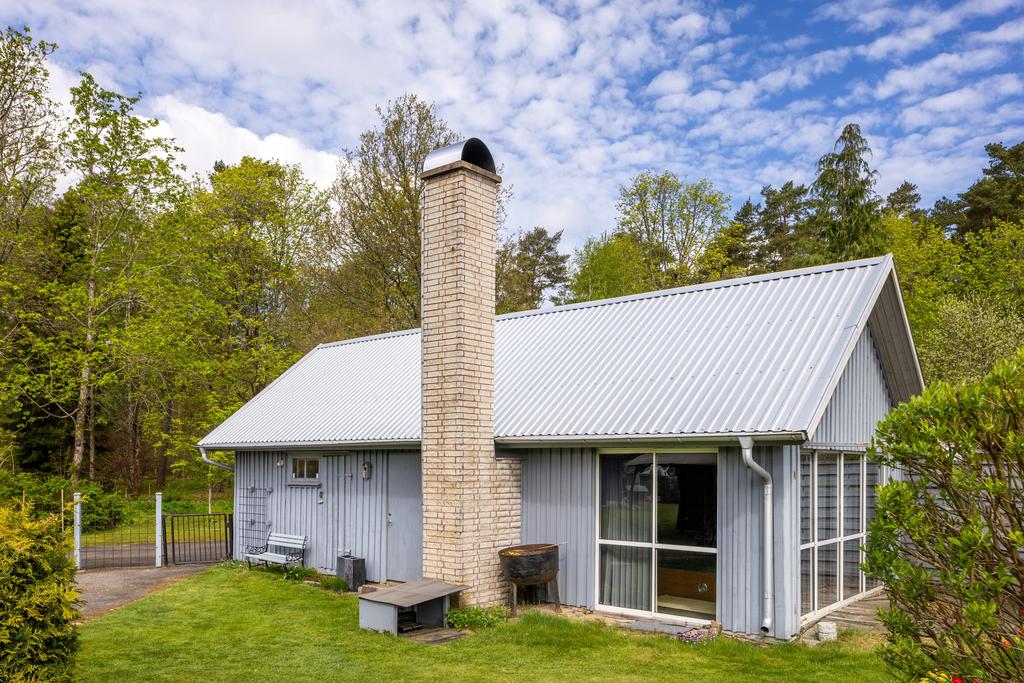 Uthus med inglasad altan där det finns ett utespa.
